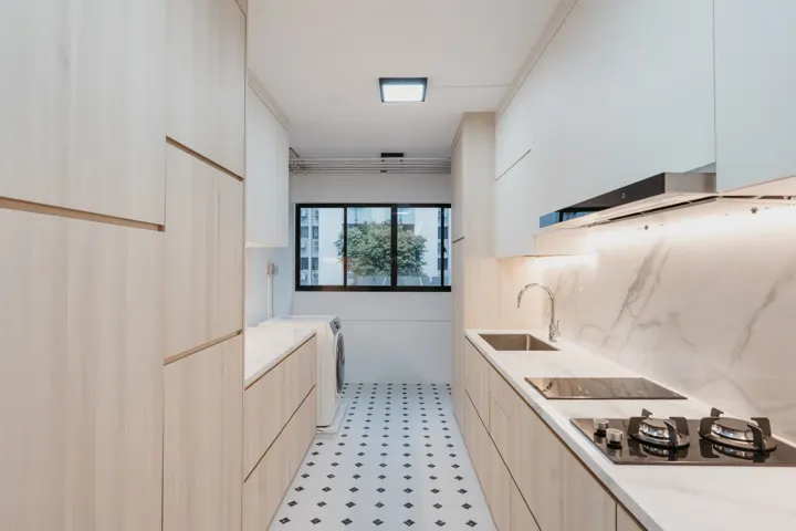 Galley kitchen with marble-look surfaces by The Masterplan Studio